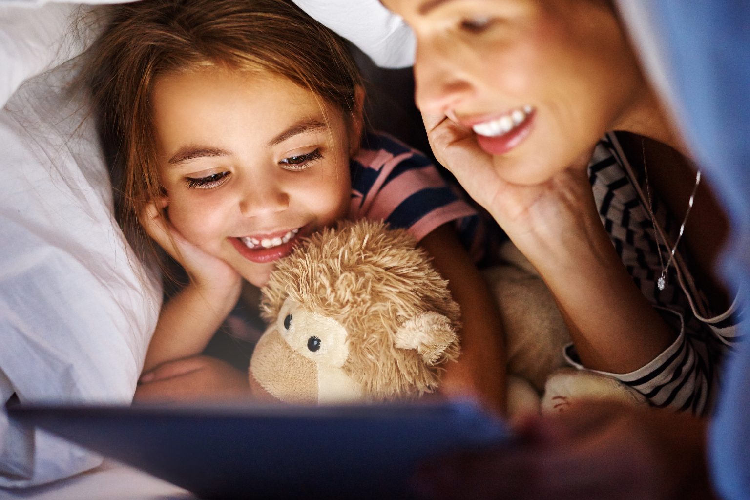 The photo visually supports the topic Calming Activities Before Sleep by showing a parent and child bonding during a bedtime story. It illustrates how storytelling creates connection, comfort, and relaxation, which are key elements of a healthy bedtime routine.