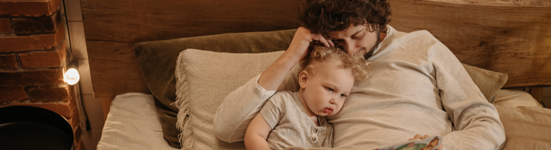 The purpose of this photo is to highlight the role of bonding and bedtime routines in building healthy sleep habits for children. It shows how quiet, comforting moments with a parent can support better rest.
