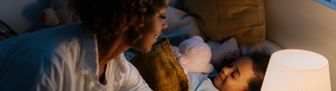 he photo illustrates the calming bedtime bond between parent and child, highlighting the importance of creating a secure and consistent environment to support quality sleep for kids.