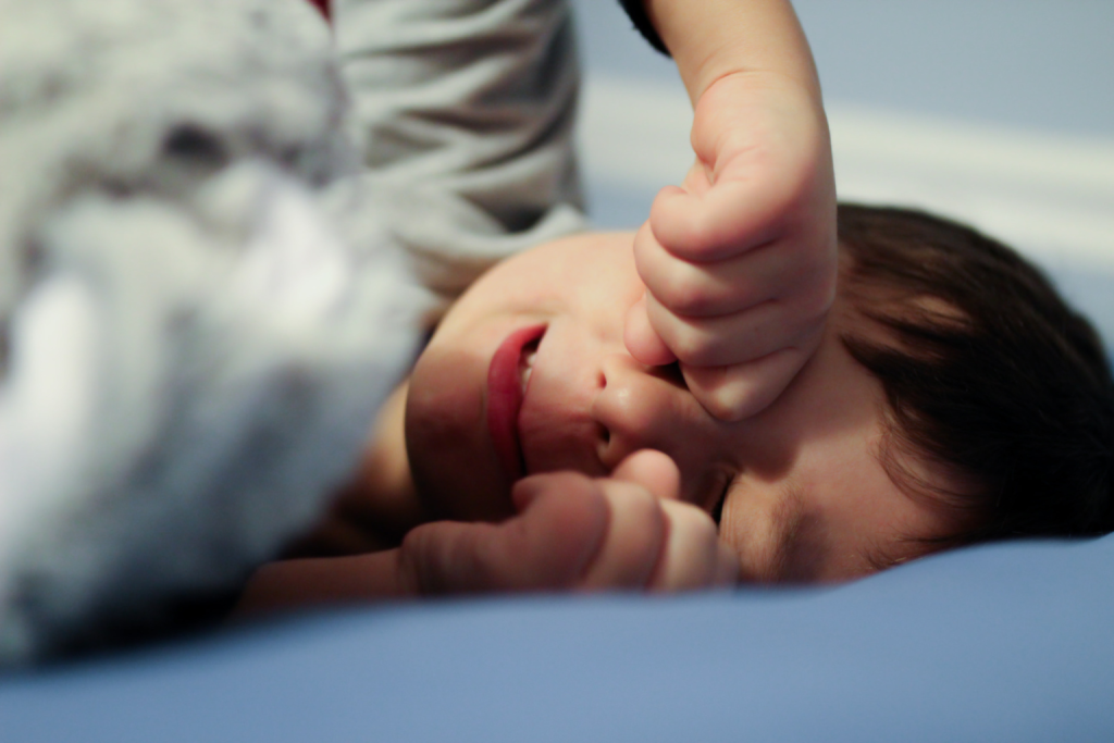 The purpose of this photo is to highlight the challenges parents face in building healthy sleep habits for toddlers, showing the emotional struggle that can come with bedtime routines and sleep regression.