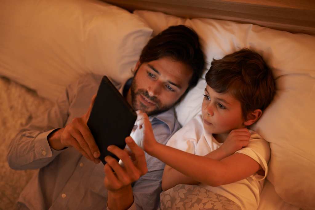 Parent and child while reading a story in bed.
