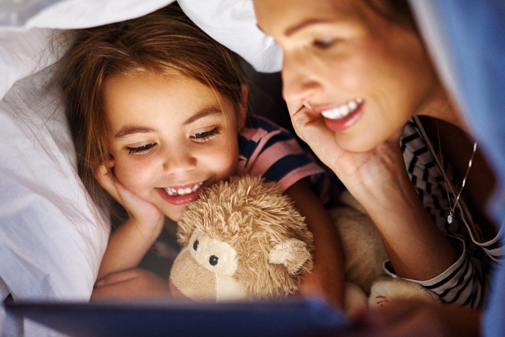 Parent and child using a bedtime app on a tablet together, showing how storytime strengthens connection and sparks creativity beyond bedtime.