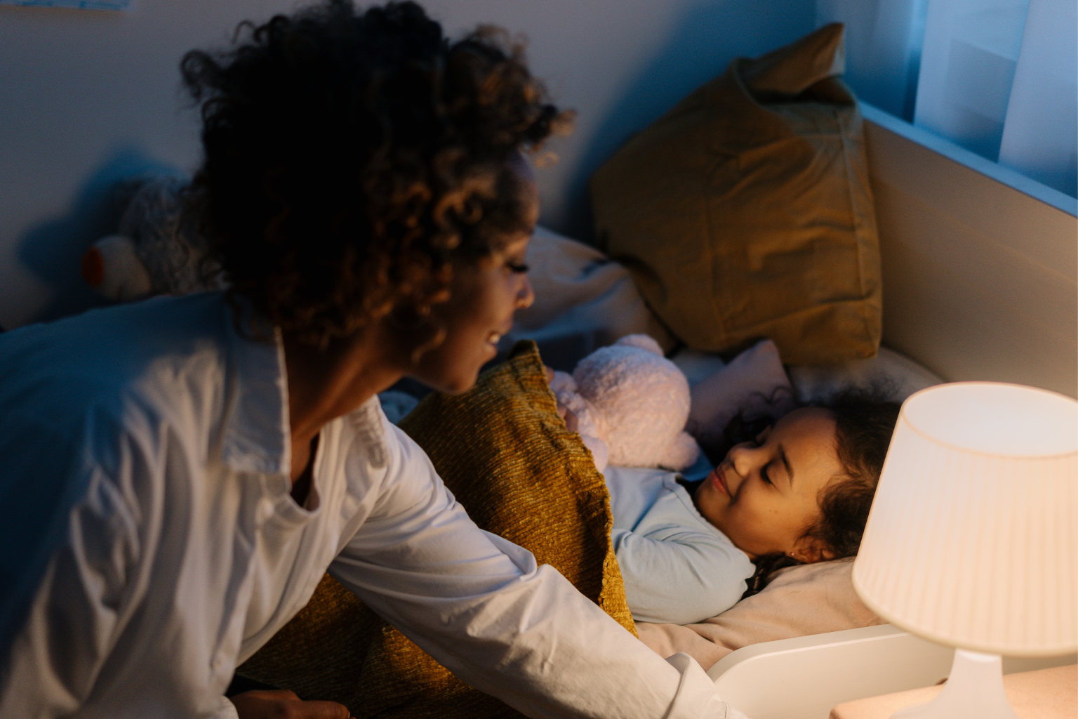 Peaceful bedtime environment with toddler snuggling stuffed toy at night.