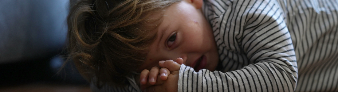 Photo illustrating a child resisting sleep as part of a bedtime routine challenge.
